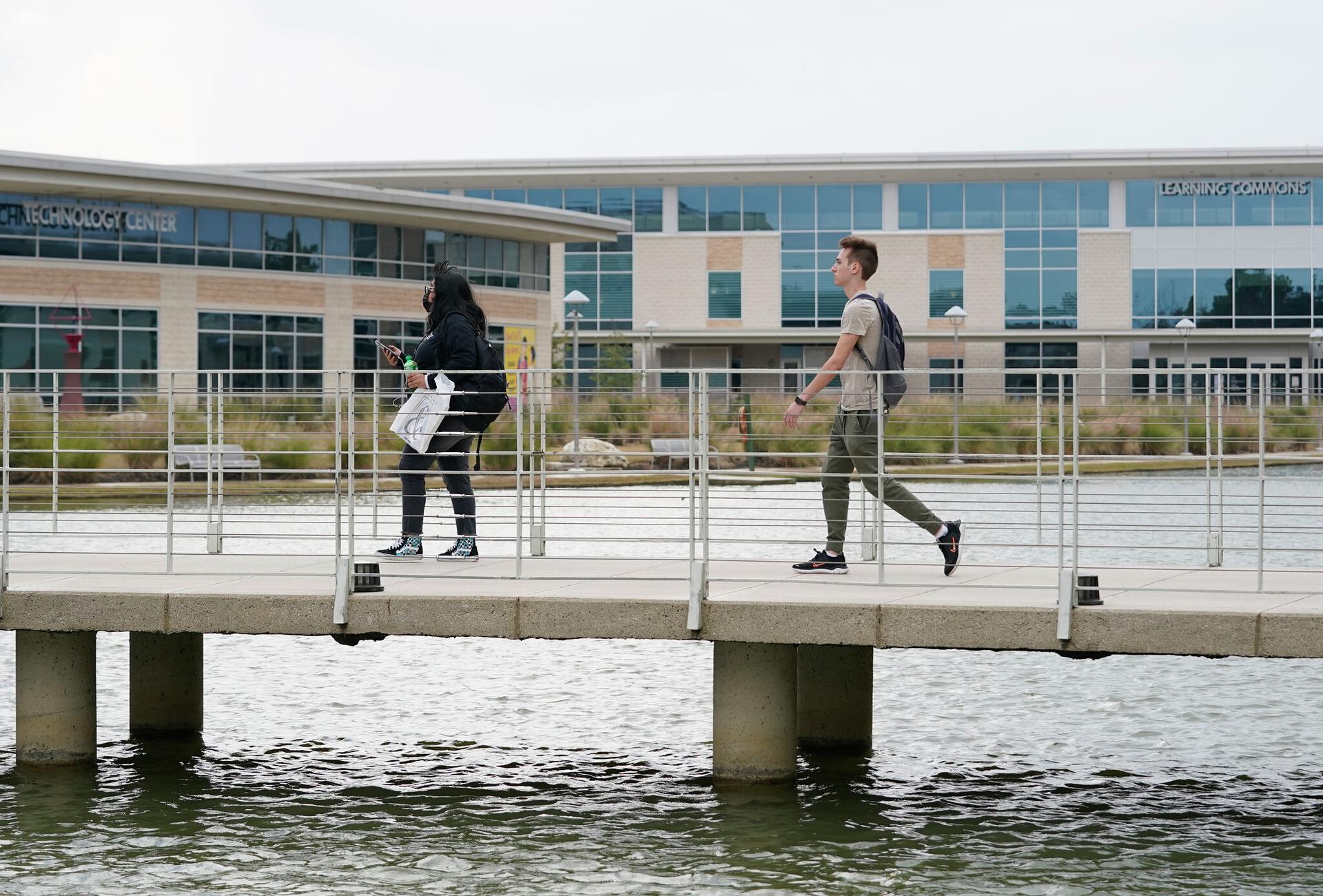 Students walk across a bridge on the campus of Lone Star College-CyFair.
