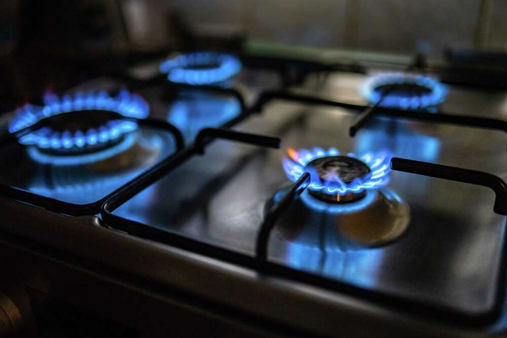 A gas stove with all four burners lit. 