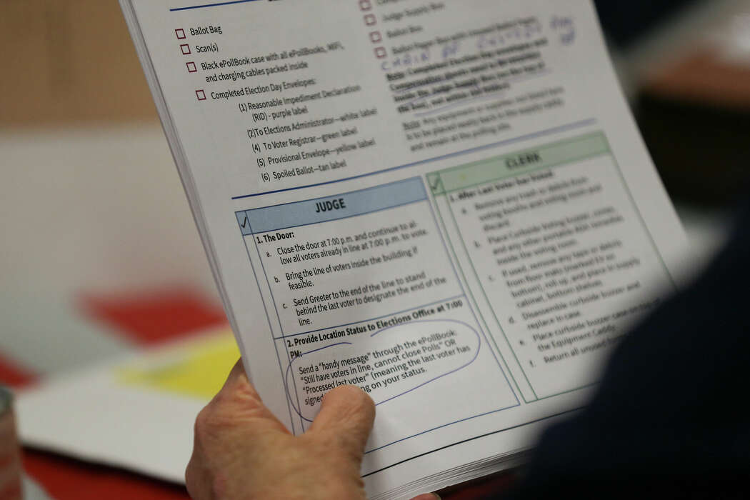 Harris County election judge Poppy Northcutt looks over the instructions for closing down the polling station at the end of the day at the voting site for the primary runoff election at La Quinta Inn near the Galleria in Houston 
