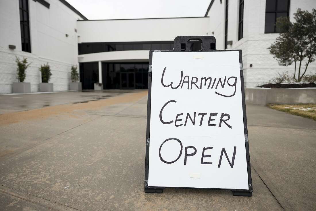 A sign on a sidewalk outside a church reads ''Warming center open.''
