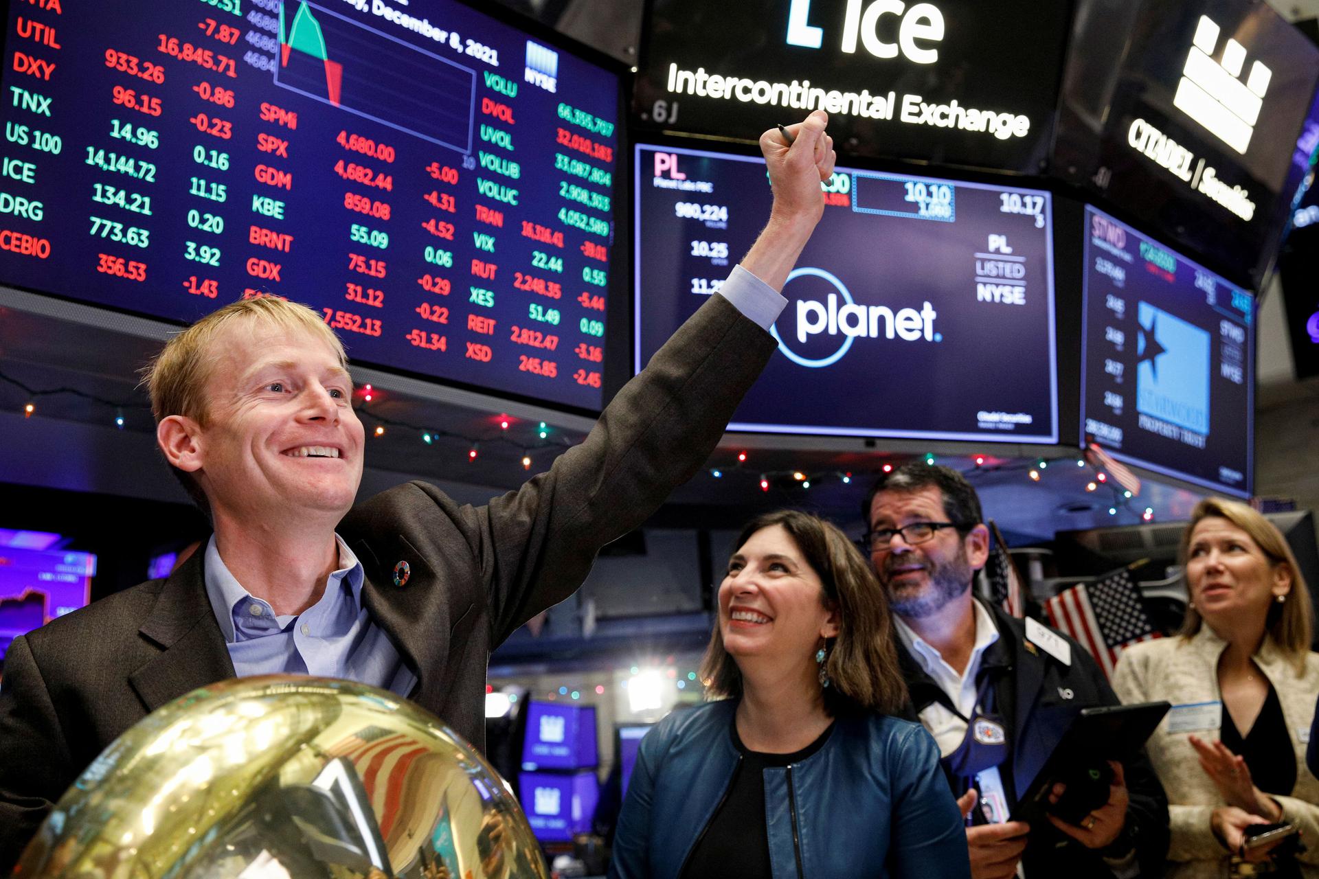 Planet CFO Ashley Fieglein Johnson, furthest right, looks on as cofounder and CEO Will Marshall, furthest left, celebrates the company's listing on the floor of the New York Stock Exchange.