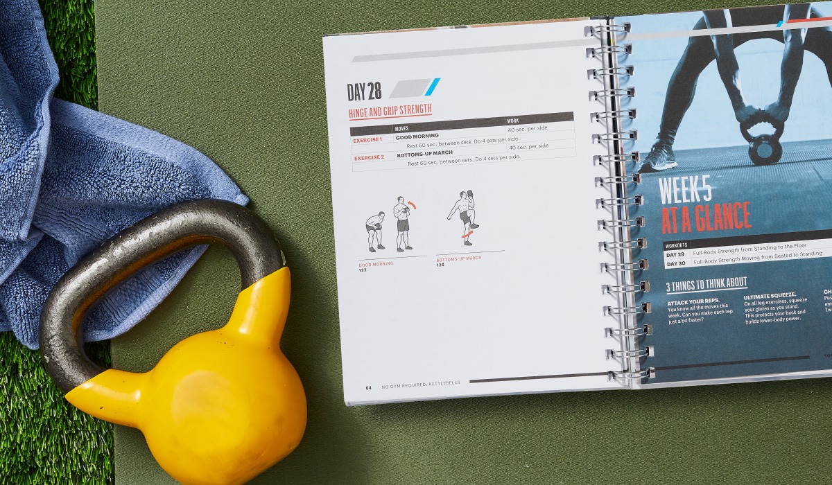 open book laying on workout mat next to yellow kettlebell and towel
