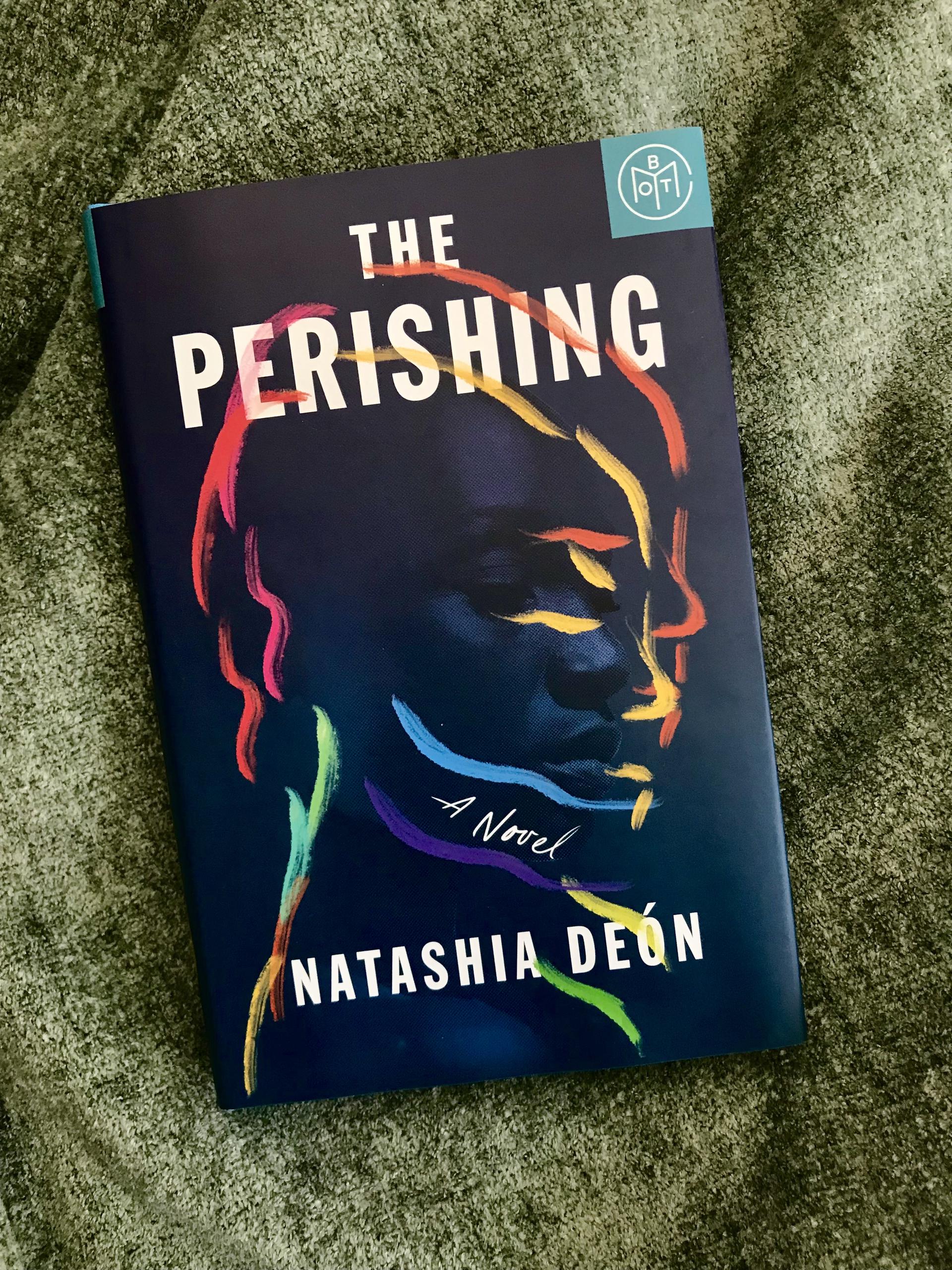 a hardcover of the perishing sits against a rough textured fabric