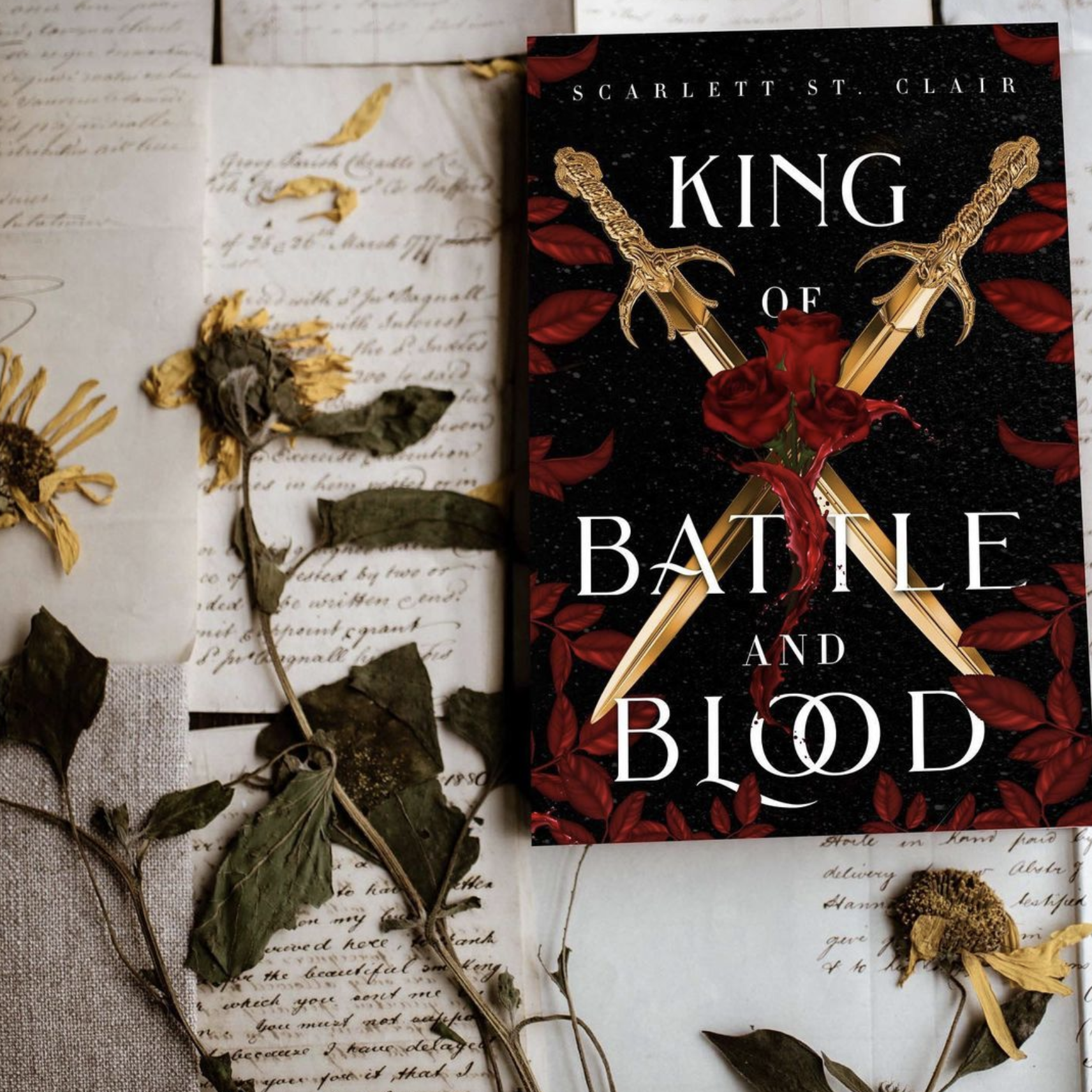 a copy of the book sits against handwritten notes and dried, pressed flowers