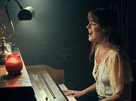 A person playing the piano and singing. 