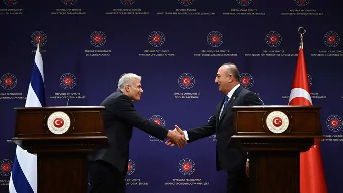 Israeli Foreign Minister Yair Lapid and Turkish Foreign Minister Mevlut Cavusoglu shake hands during a press conference in Ankara, Turkey.