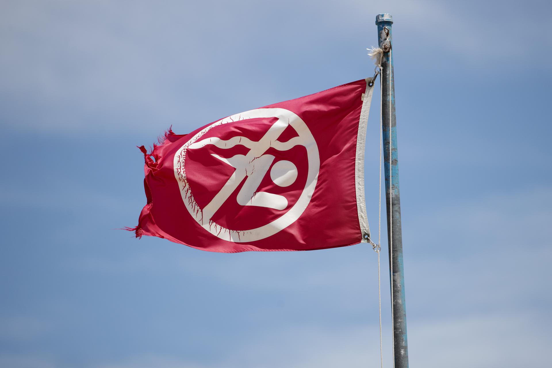 A red flag flies over Grand Haven State Park on a windy day signifying that no swimming is allowed 