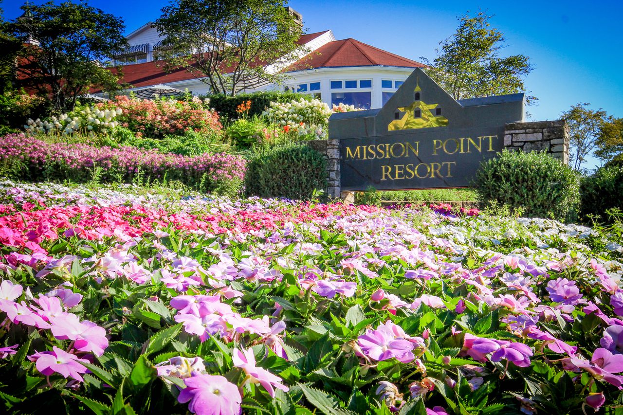The sign for Mission Point Resort in the middle of a giant flower bed
