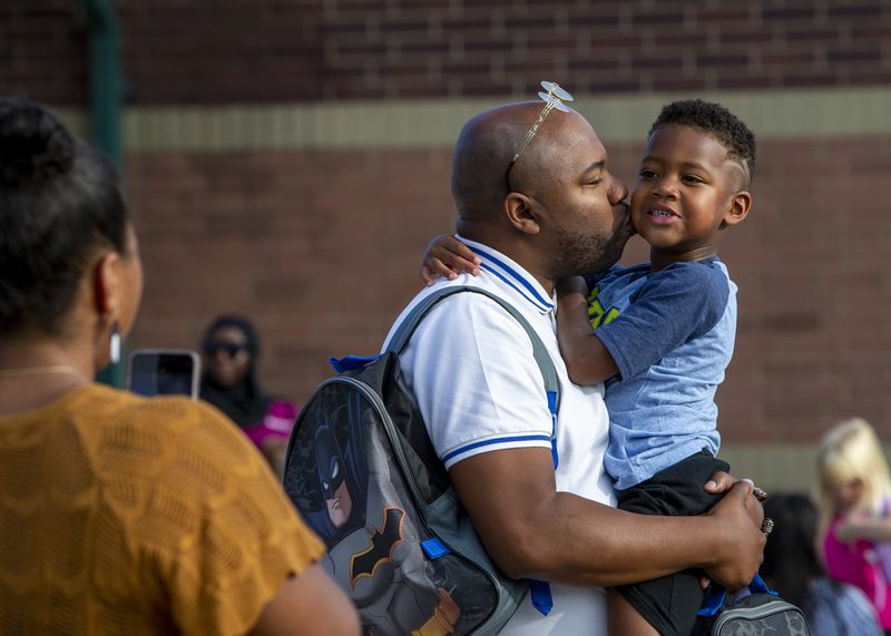 Mark Rigsby Sr. kisses his 5-year-old son, Mark Jr., on his first day of kindergarten at Kentwood Public Schools' Explorer Elementary School 
