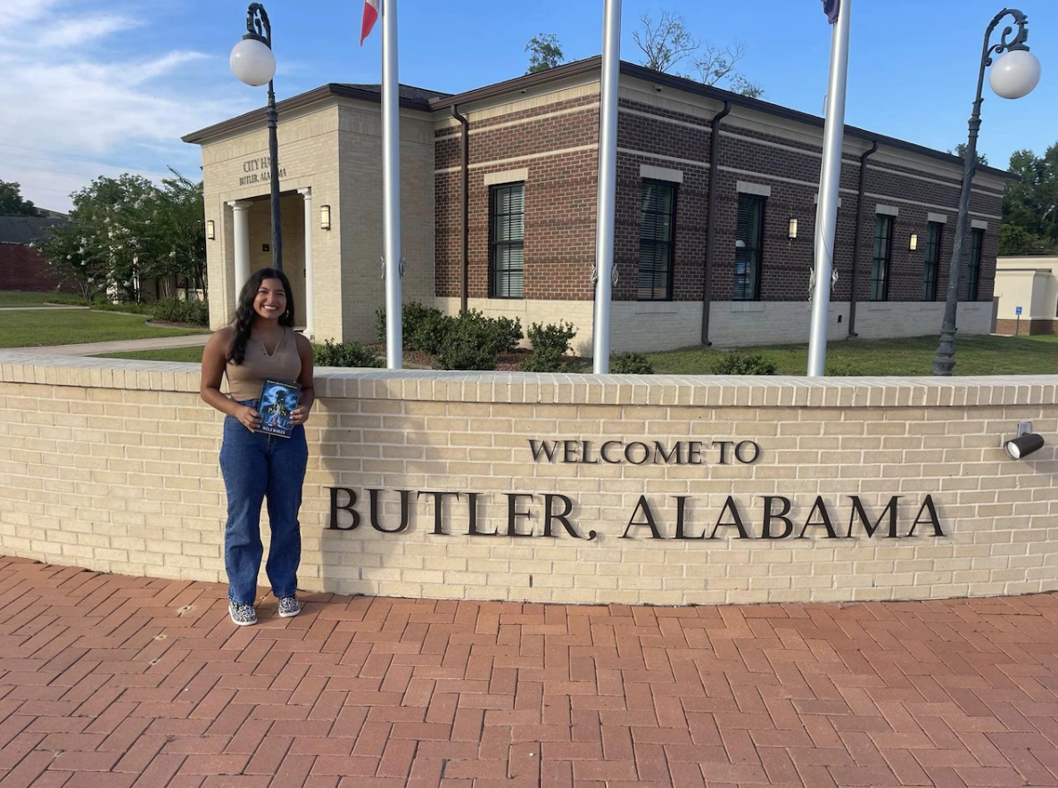 a butler resident holding a book outside town hall 