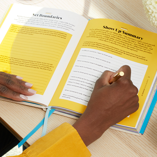 woman writing on the ''Show Up Summary'' page of the Becoming Unstuck Journal