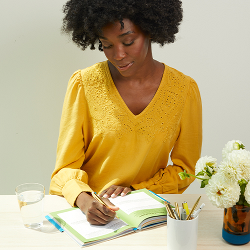 woman writing in the Becoming Unstuck Journal
