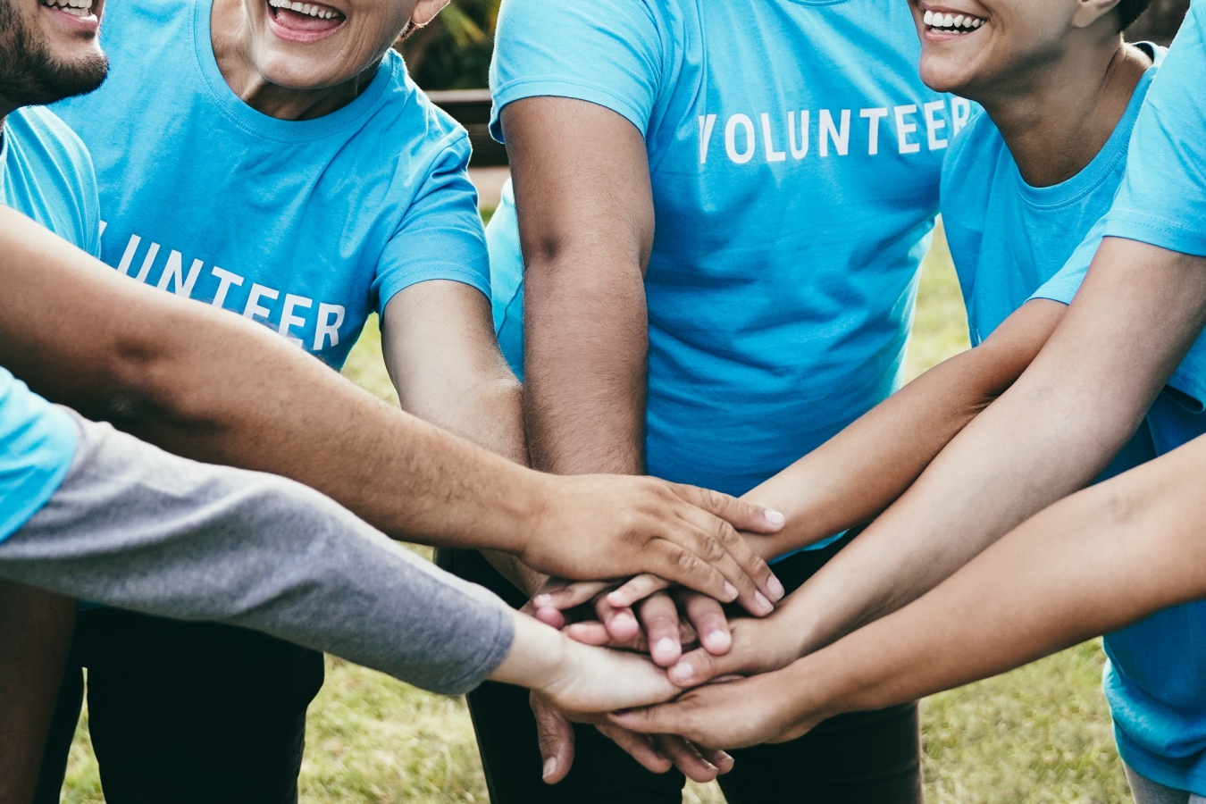 Five people with ''Volunteer'' T-shirts talk in a group