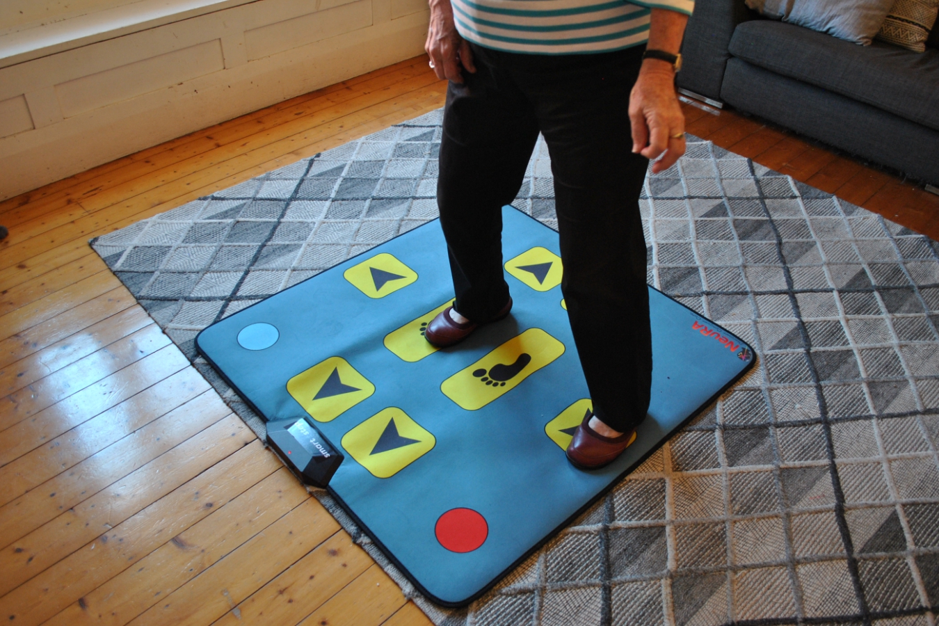 An older lady places her feet onto arrows on a mat