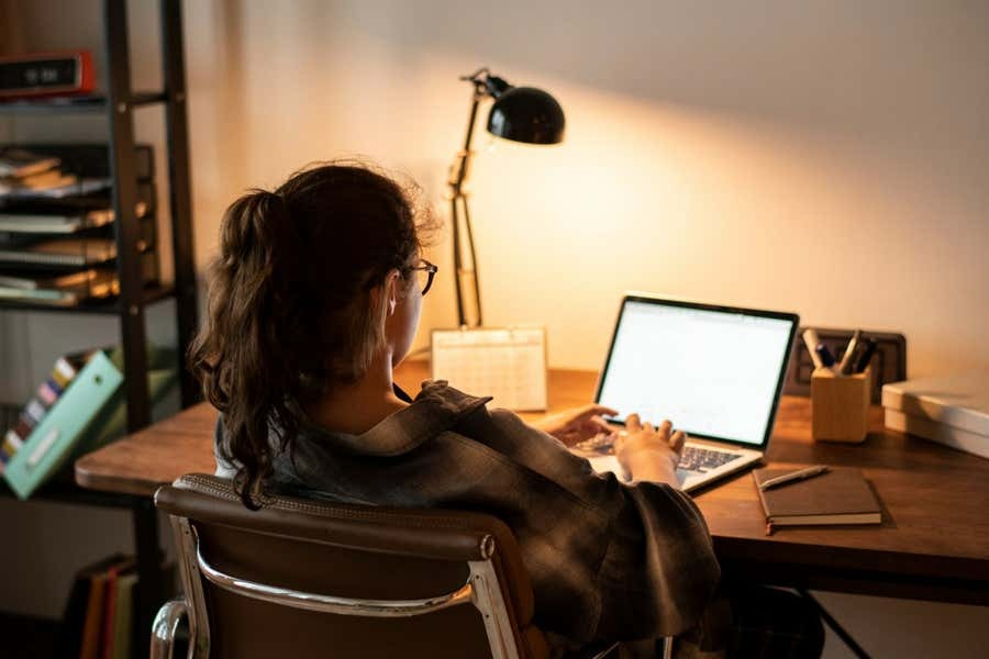 A woman is sitting at her desk working on her computer. 