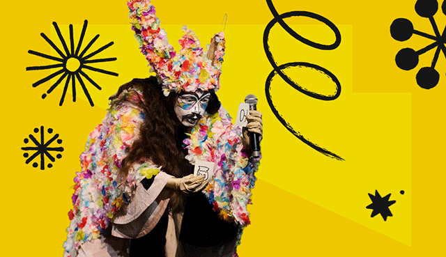 A photograph of a person in a white costume, covered with petals, they are wearing a mask and holding a piece of paper containing a symbol in both hands. The photograph is surrounded by a colorful frame with scribbles.