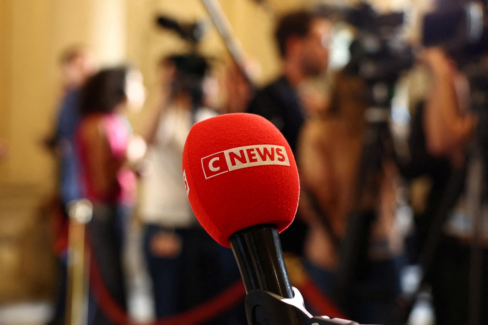 The logo of CNEWS is seen on a microphone as journalists work at the National Assembly in Paris