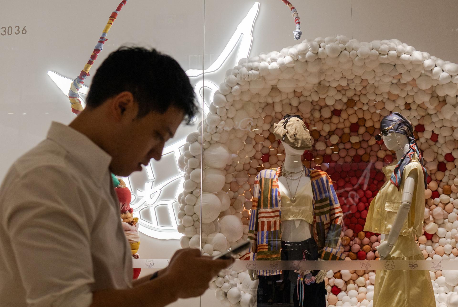 A man walks past a clothing store in Beijing