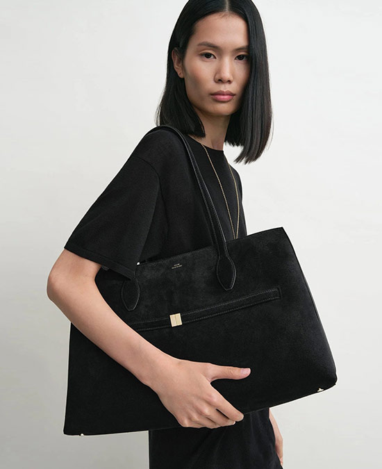 Model carrying the Toteme belted suede bag