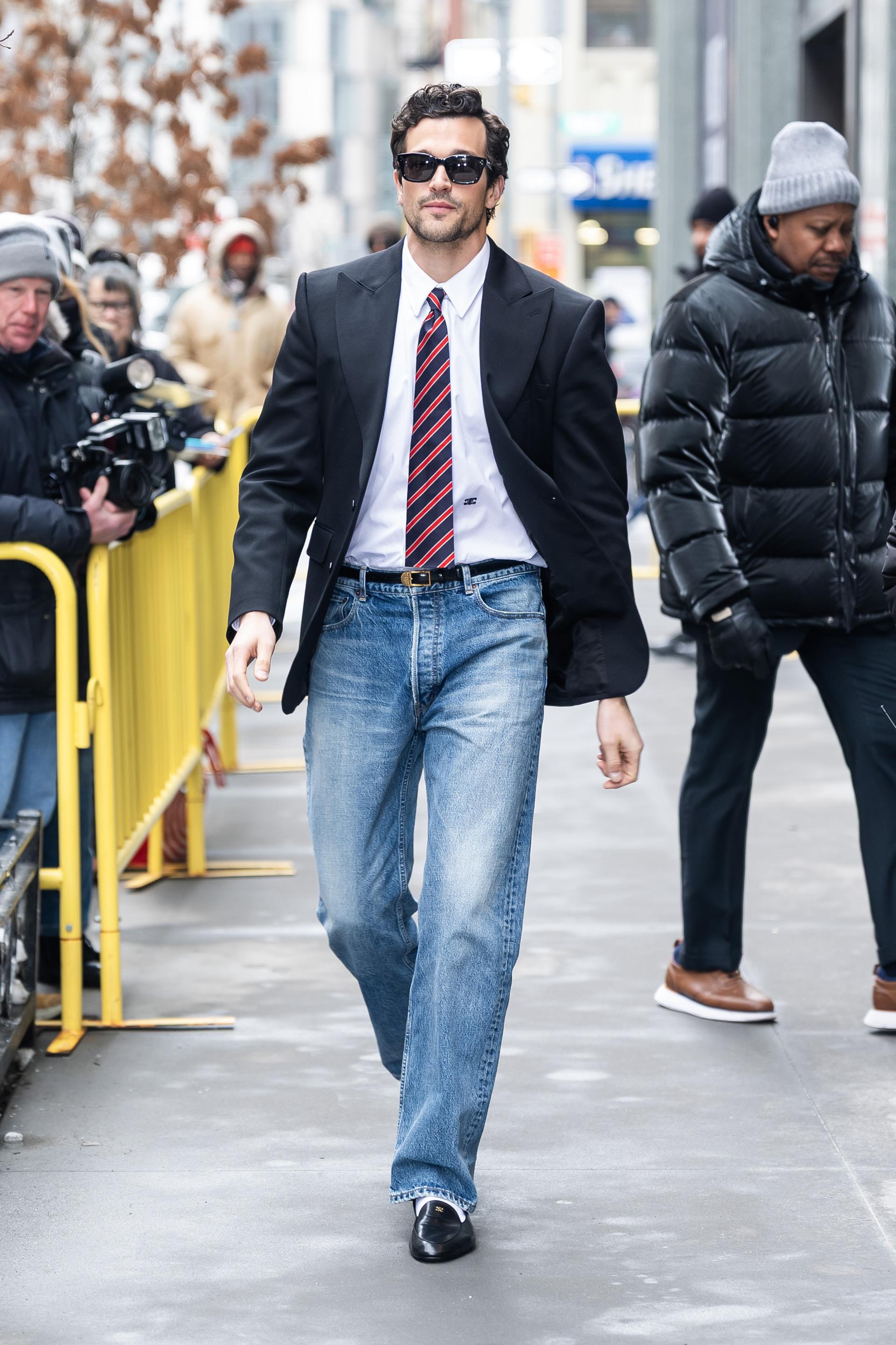 man walking down the street in jeans and blazer