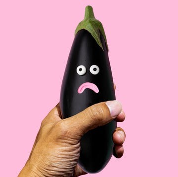man holding an eggplant with a frowning face