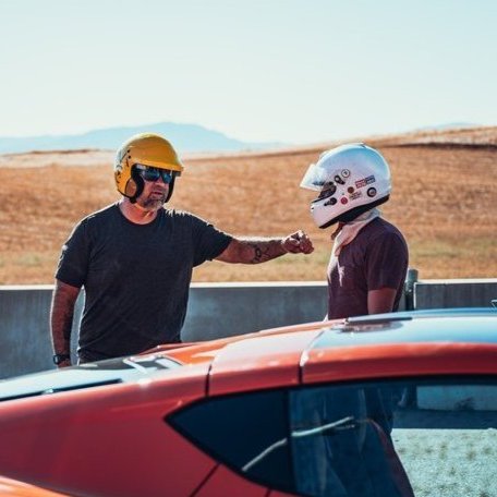 two people wearing helmets at racetrack 