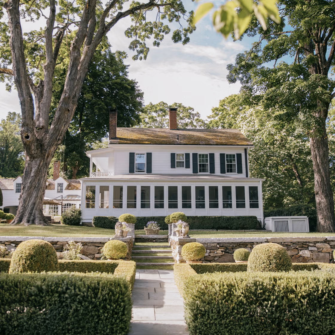 White house with hedge-lined path