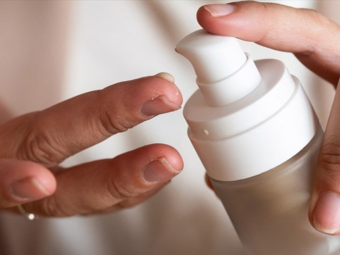 person putting on skin care