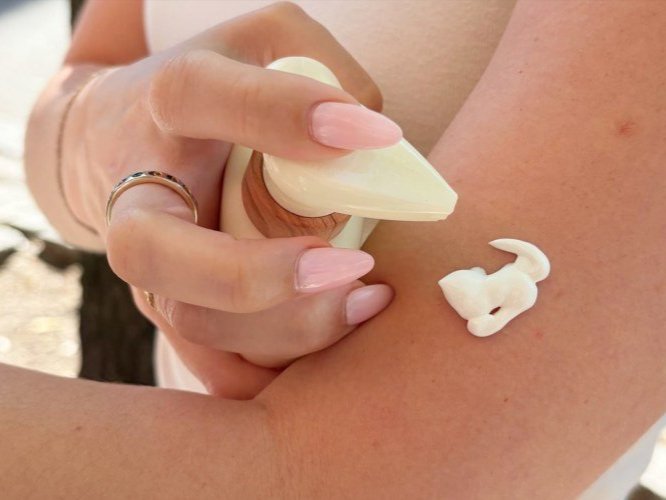 Person using sunscreen on arm