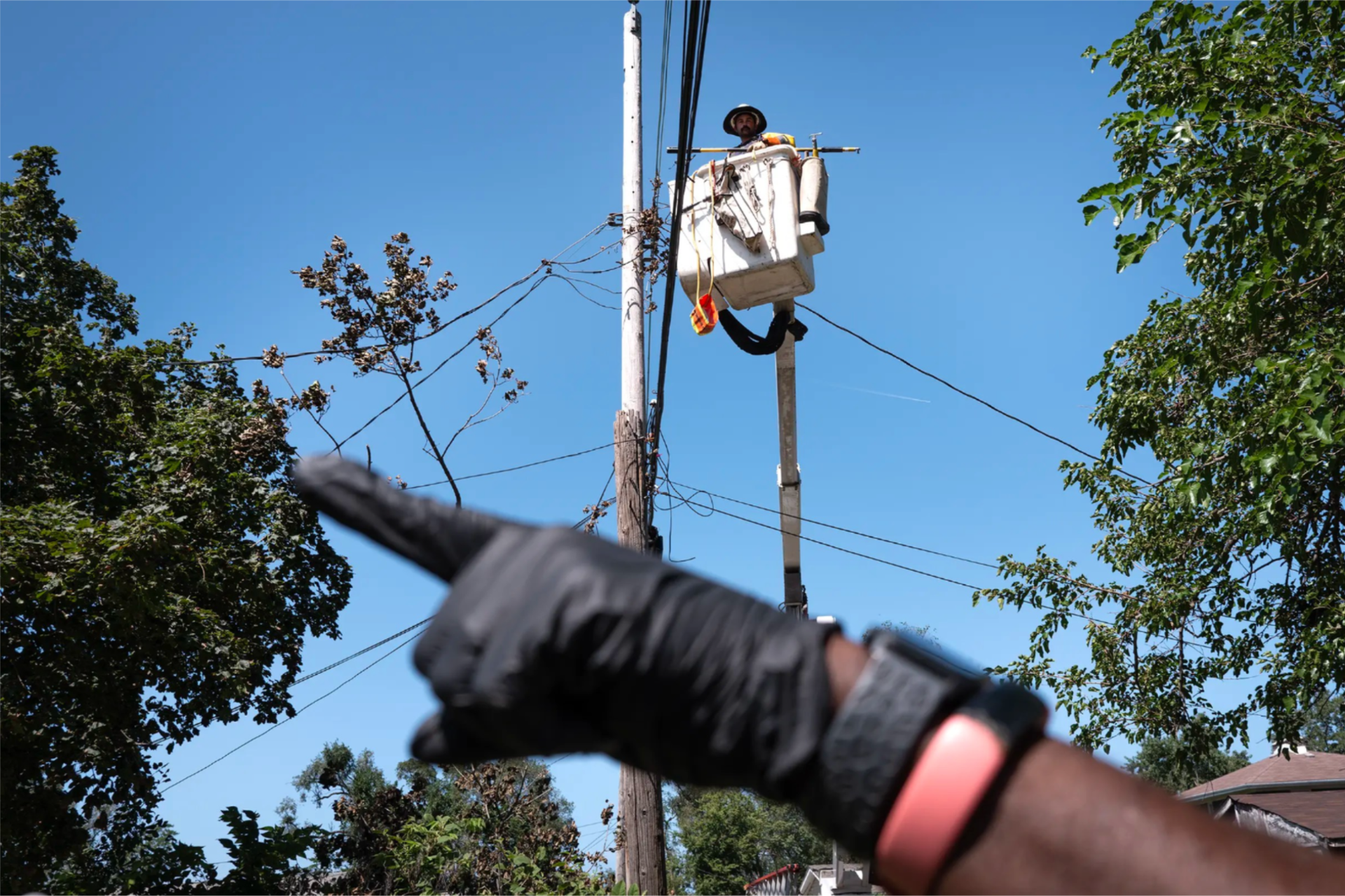 A resident queries an electrical worker about when he can expect power to be restored to his home on Aug. 20, 2026 in Gary, Ind.