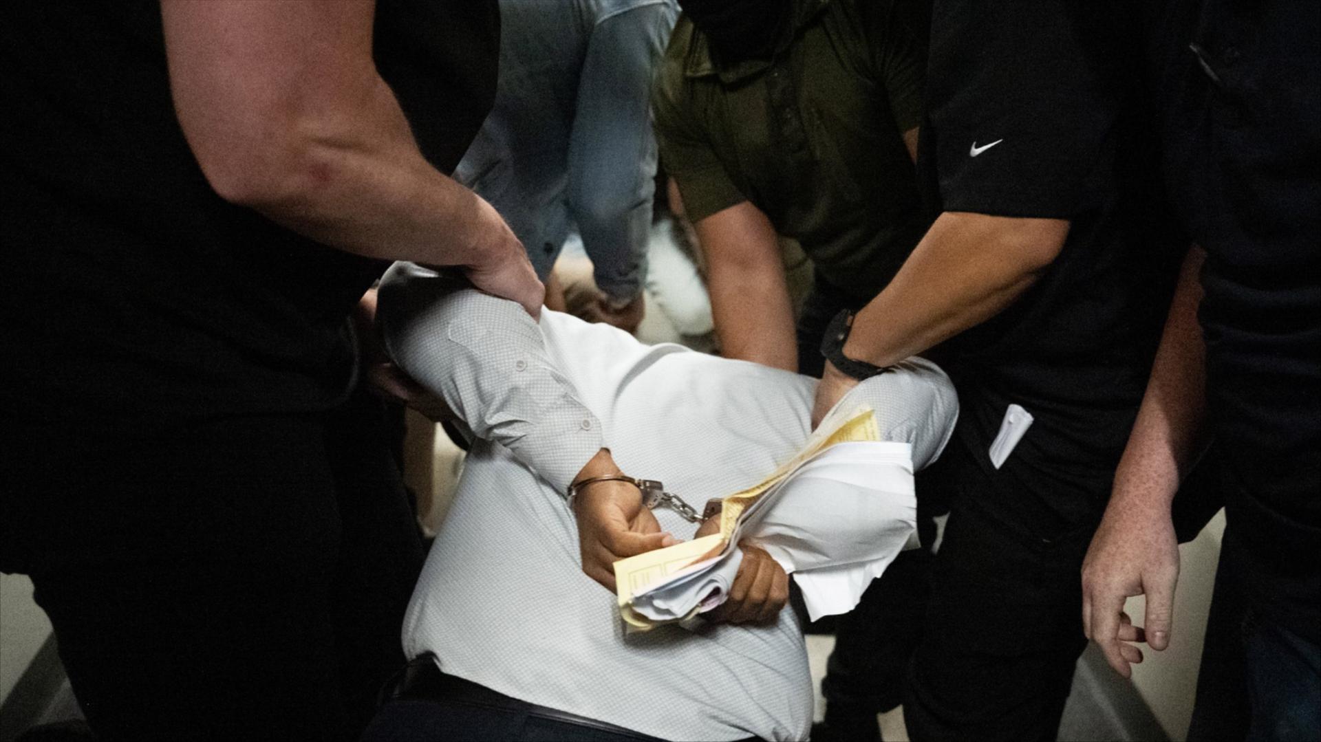 ICE agents detain a person as he exits an immigration courtroom hearing at the Jacob K. Javitz Federal Building