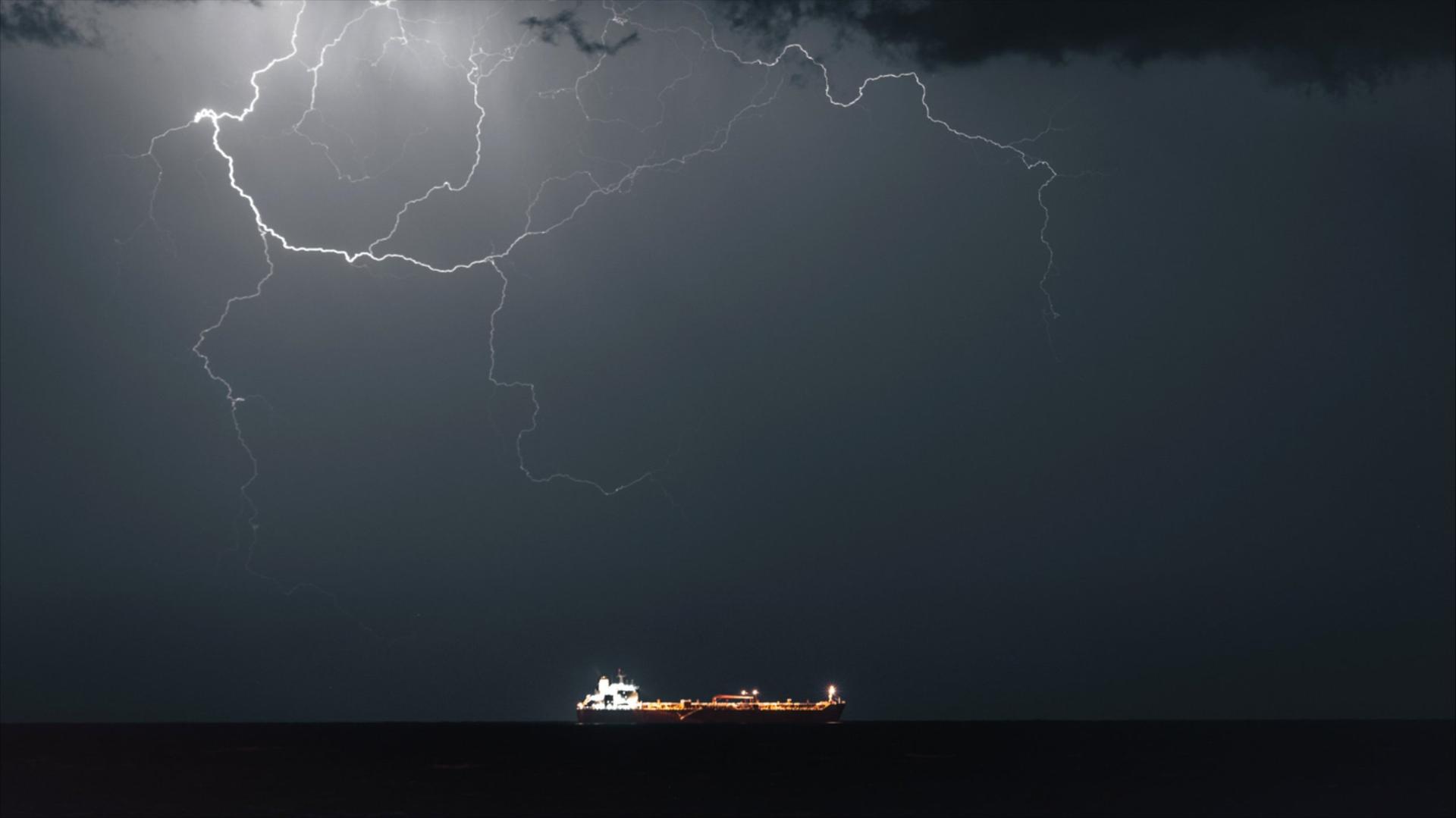 A wide frame of an oil tanker on the water at night