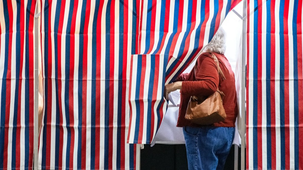 A person enters a voting booth at a polling station on Nov. 5, 2024 in Colebrook, N.H.