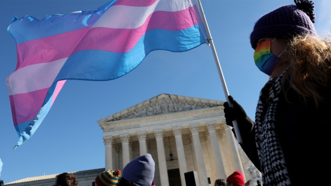 A person waves a transgender pride flag outside the Supreme Court