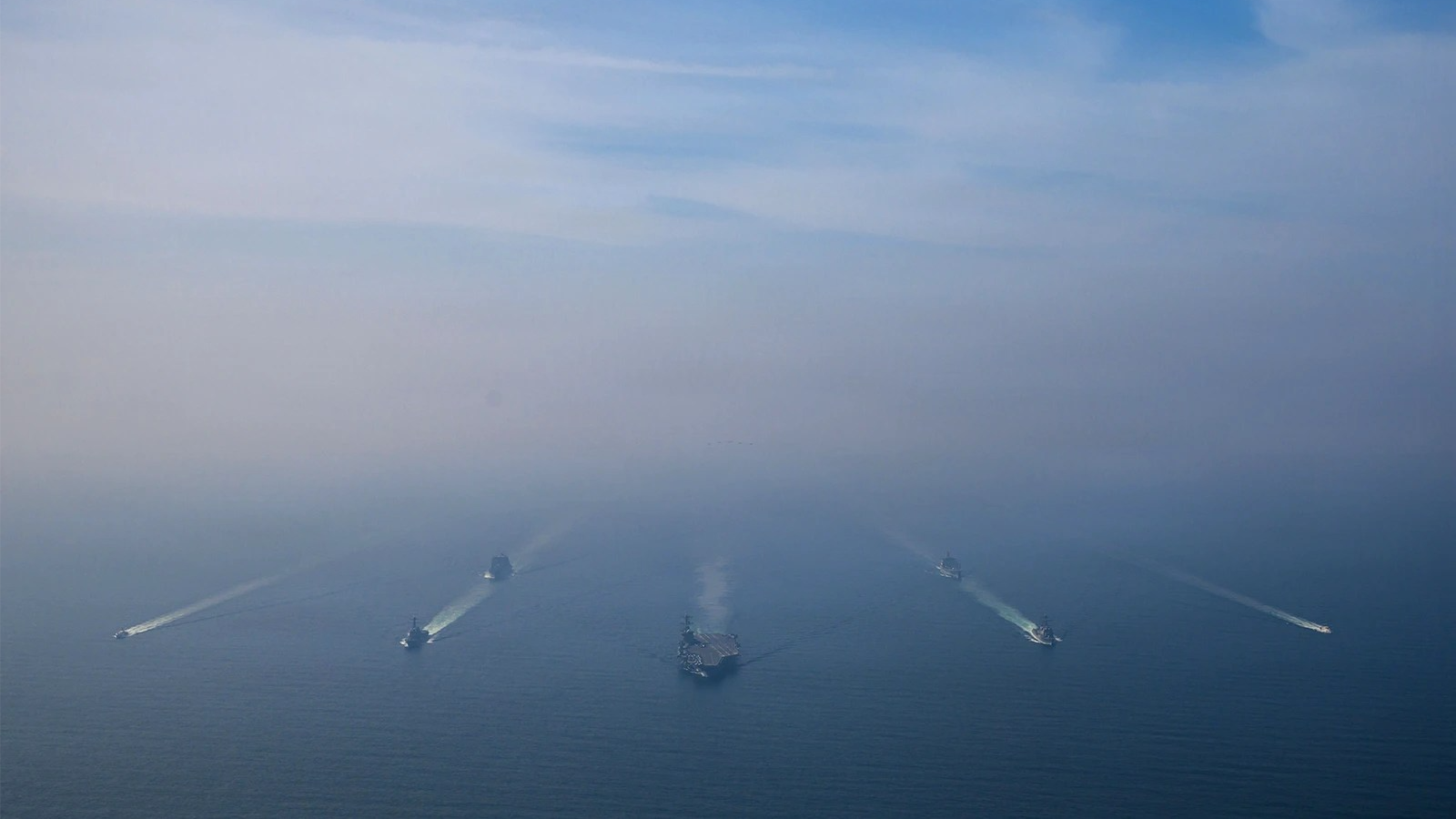 The USS Abraham Lincoln, center, sails in formation with guided-missile destroyers USS Michael Murphy and USS Frank E. Petersen Jr. as well as a replenishment oiler, a dry cargo ship and fast-response cutters on Feb. 6, 2026, in the Arabian Sea.