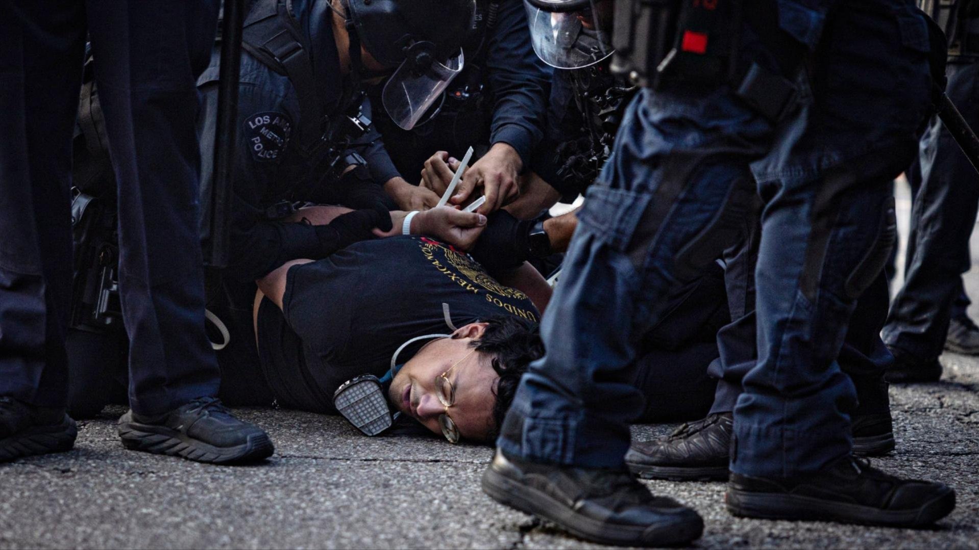Multiple LAPD officers zip tie a person