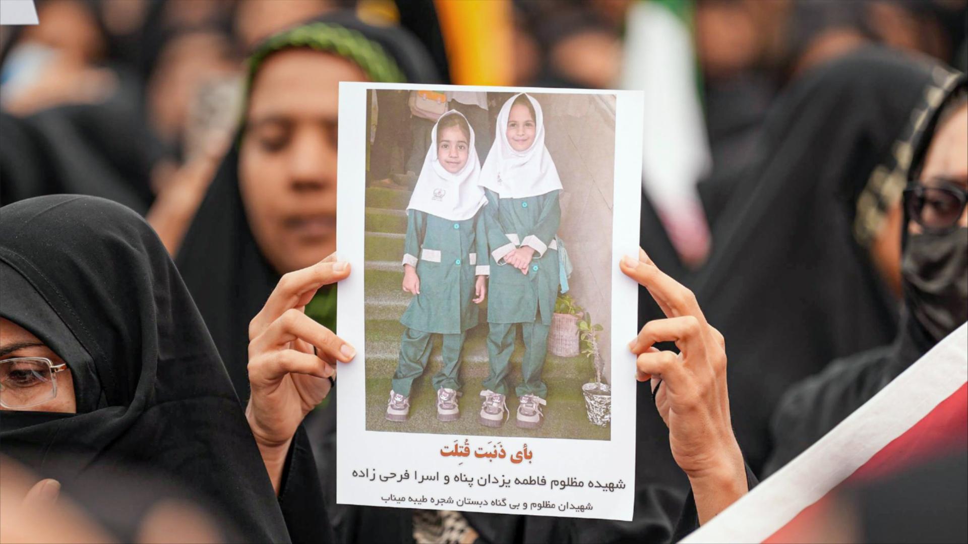 Mourners hold a portrait of a students during a funeral ceremony for people killed in strike