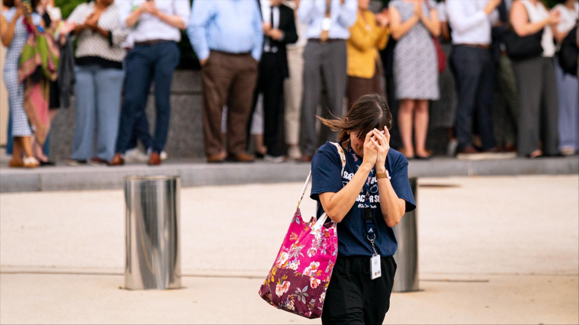 Person walks away with their head in their hands 