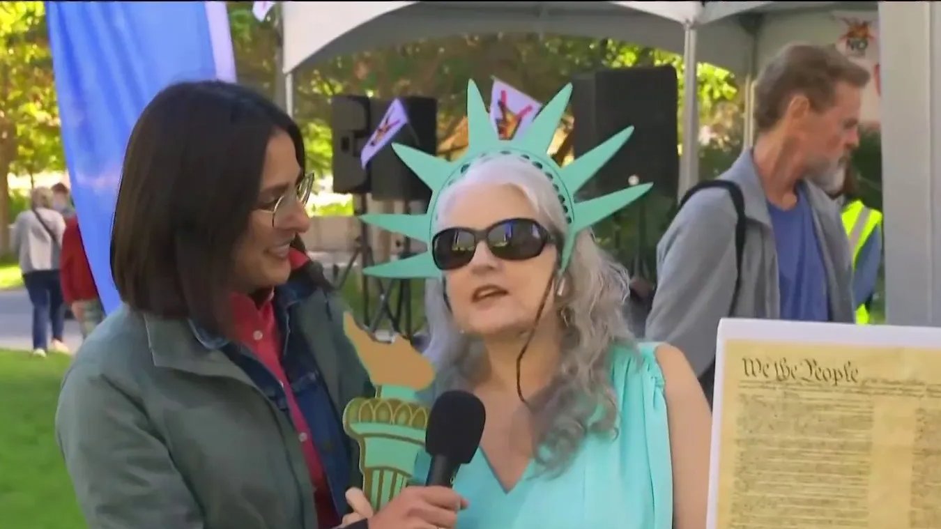 An image of MS NOW reporter Rosa Flores interviewing a woman in a Statue of Liberty costume. 