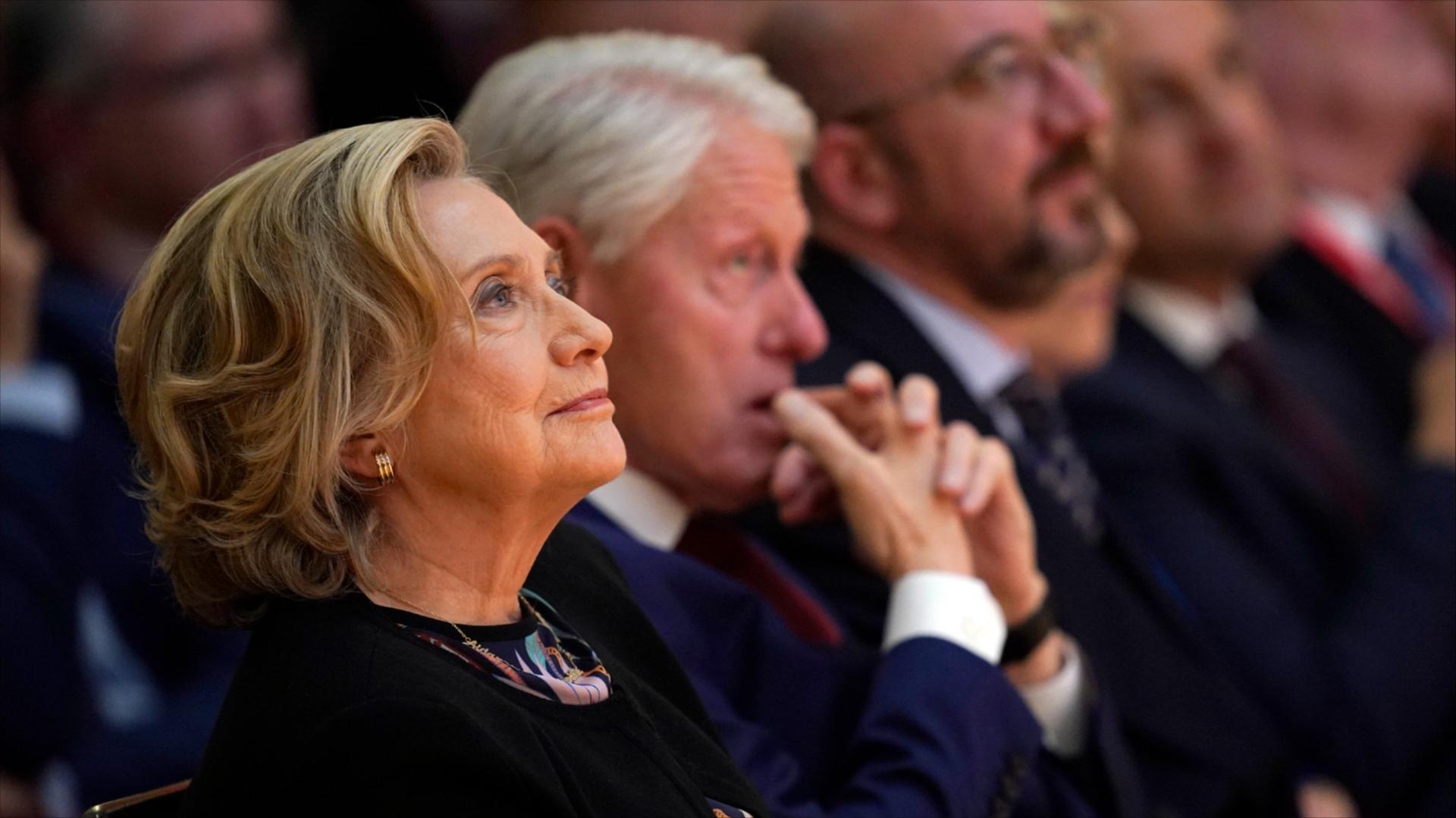 Hillary Clinton, left, and Bill Clinton sit during a conference.