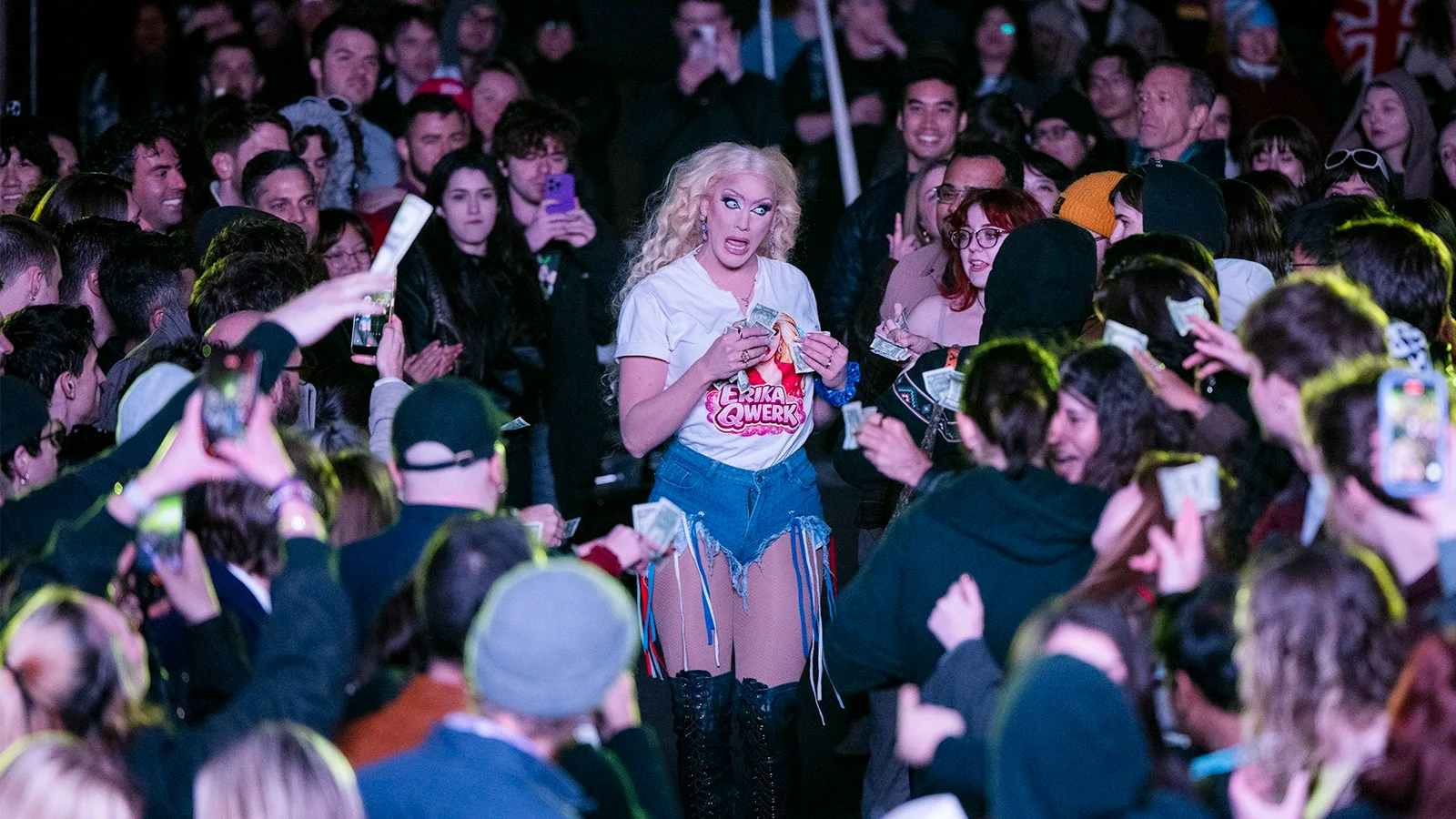 Lauren Banall walks through a crowd as she collects money.