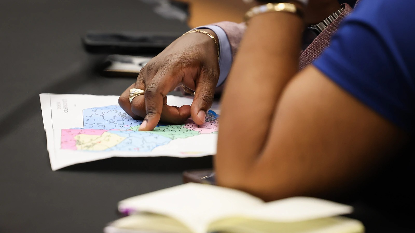 Two people, just their hands visible, look over a map of South Carolina