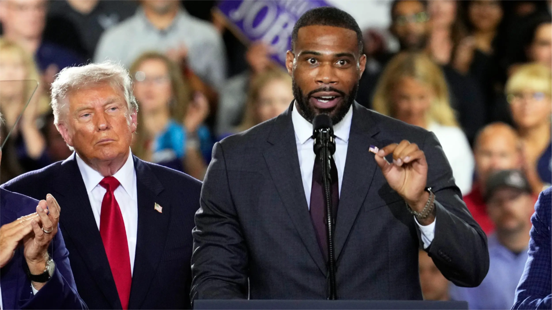 President Donald Trump listens as Republican congressional candidate Amir Hassan speaks at an event in Milford, Michigan, on July 27, 2026.