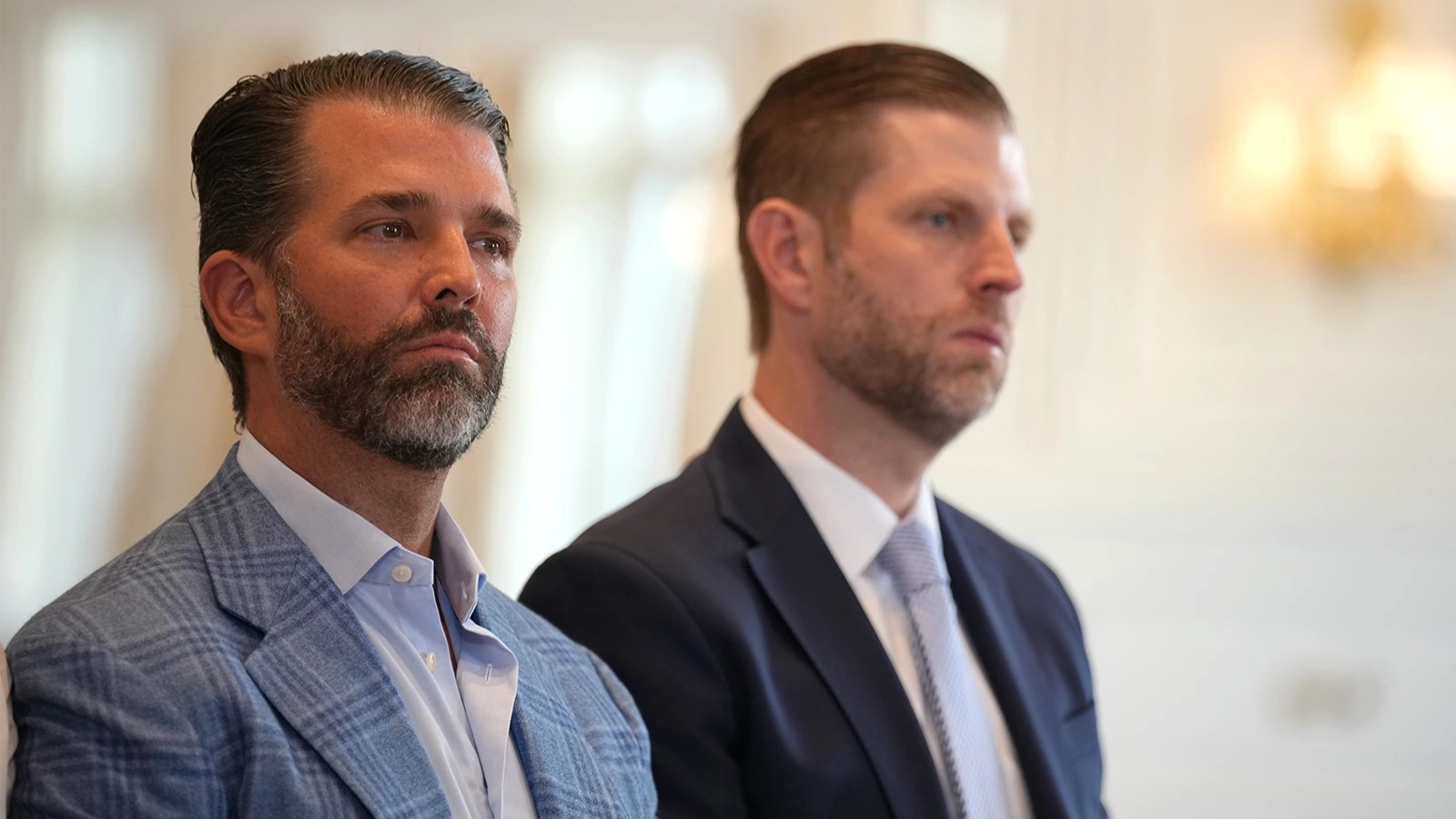 Donald Trump Jr., left, and Eric Trump look on.