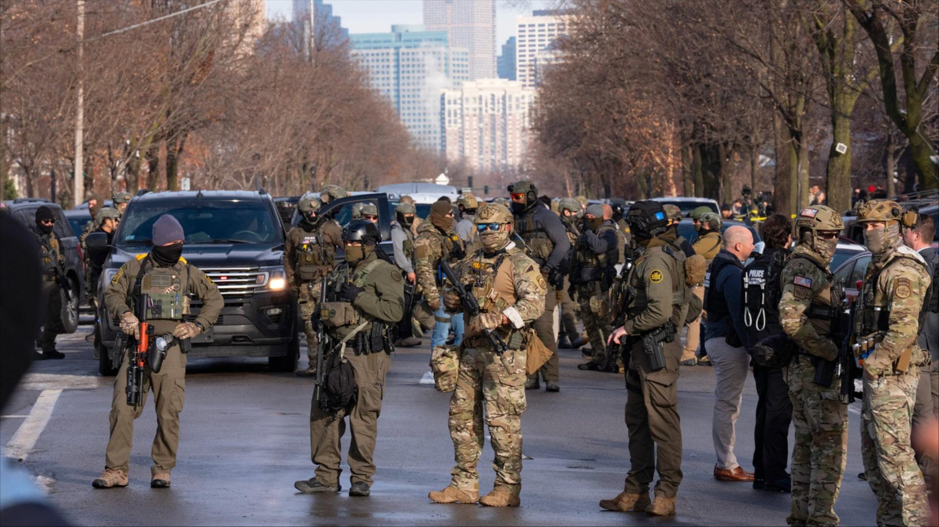 Federal agents stand near the scene where an ICE agent shot and killed a woman in Minneapolis.