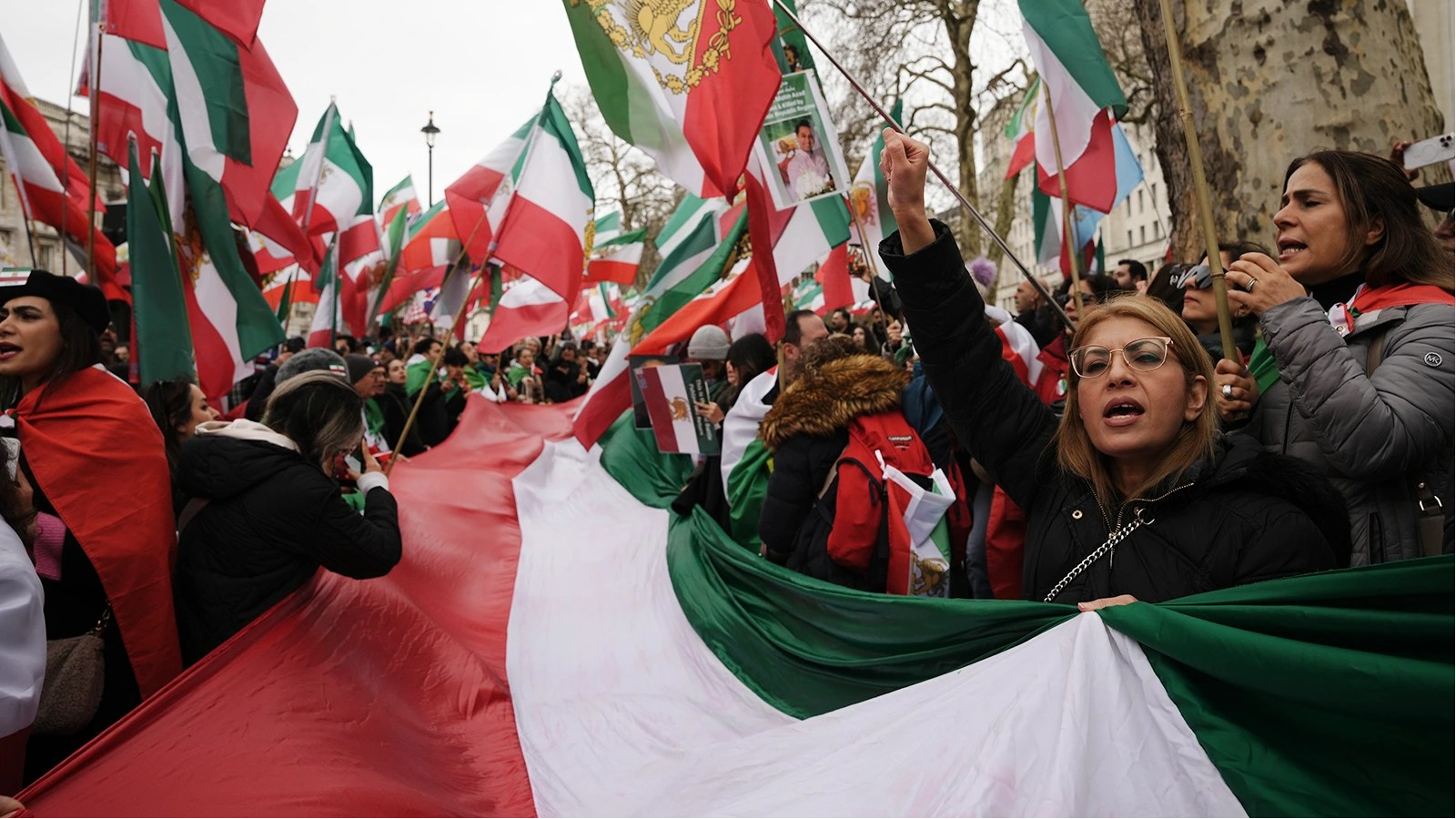 People call for a regime change in Iran, waving lion and sun Iranian flags