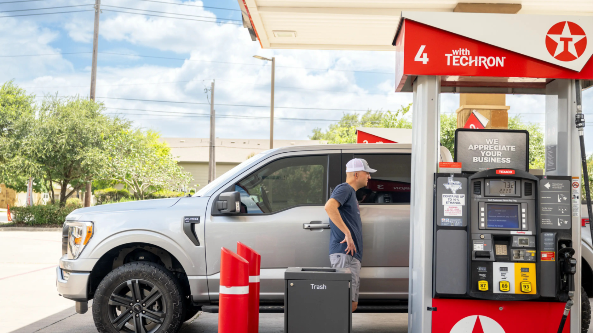 A person pumps gas at a Texaco gas station