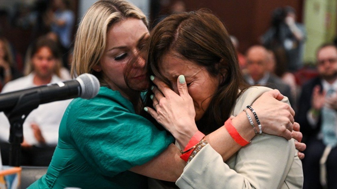 Jeffrey Epstein survivor Dani Hannah Bensky (L) consoles survivor Roza (R) 