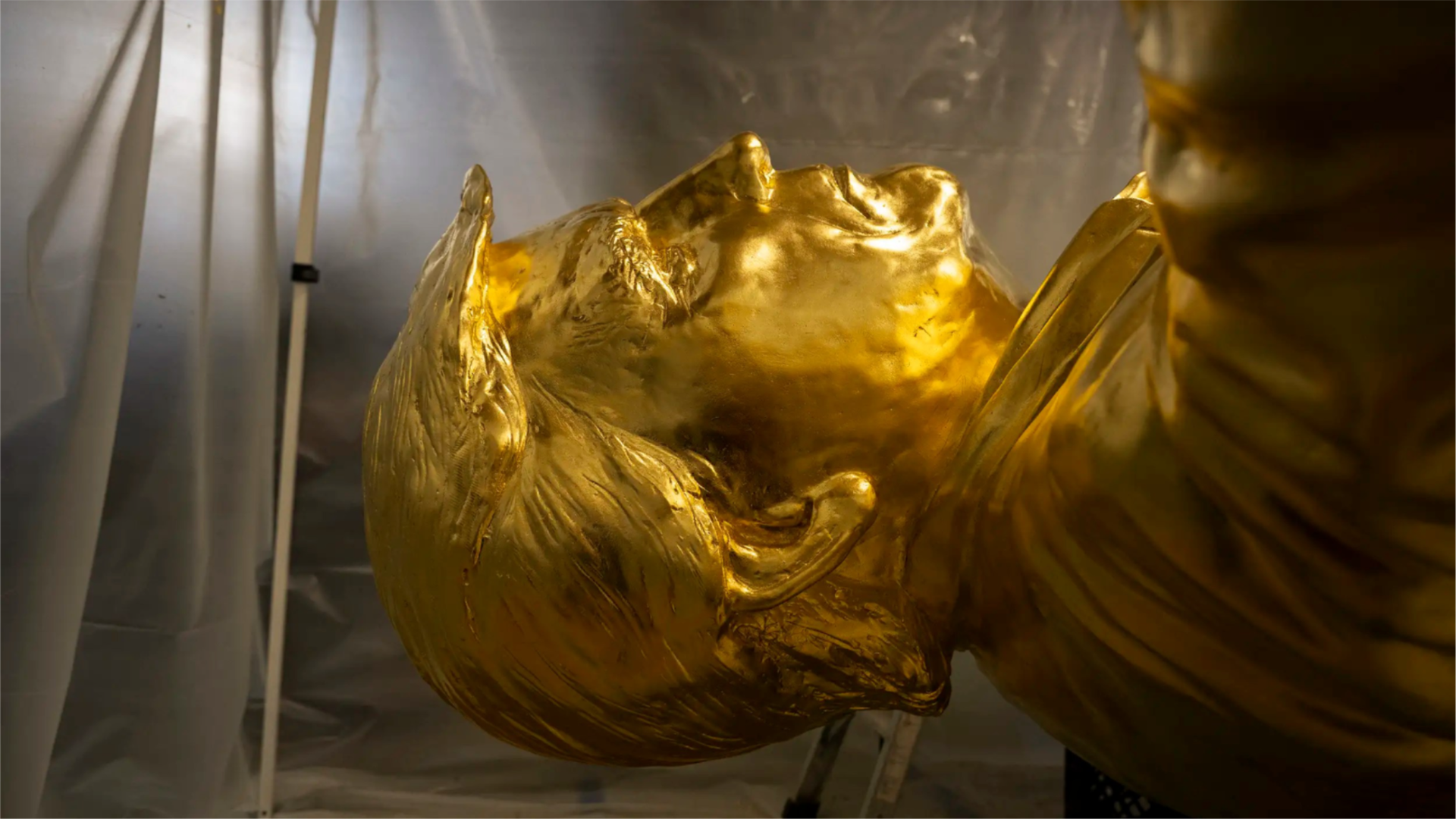 The head of a gold statue of Donald Trump laying on its back
