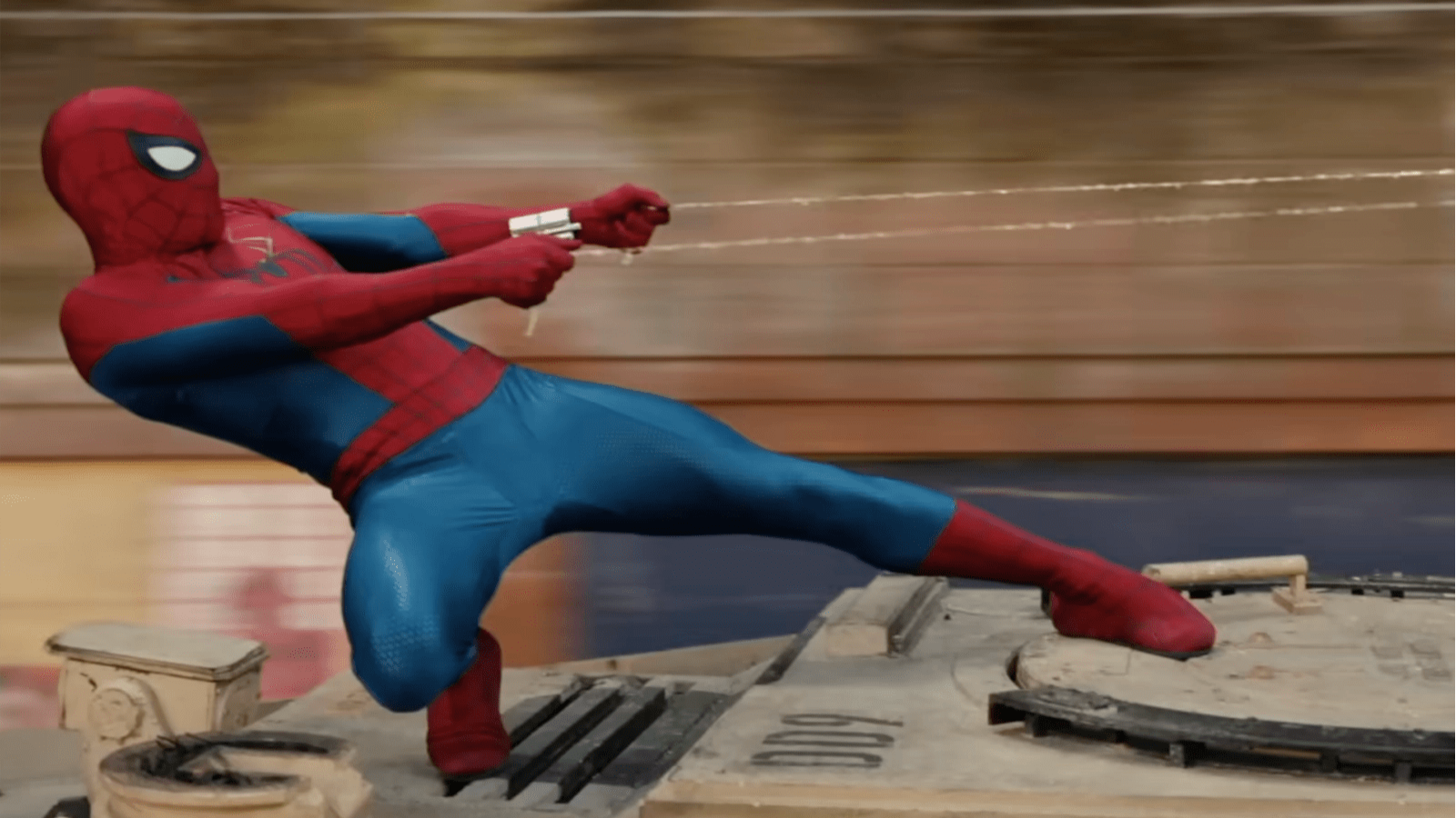 In this scene from the movie, Spiderman holds onto two pieces of web as he is standing on top of a moving vehicle.